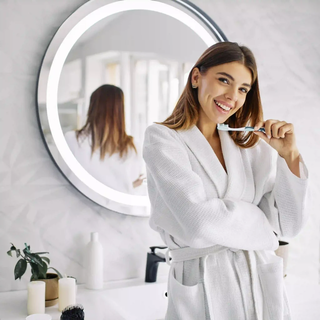 Fiatal nő fogkefét tart a kezében.